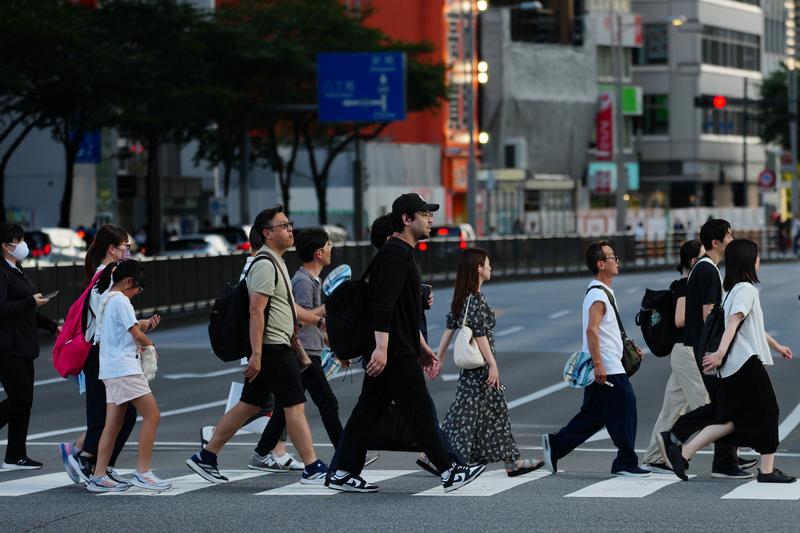 8月14日,在日本东京,人们穿过马路。新华社